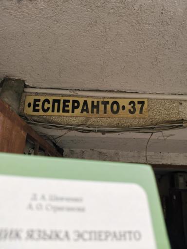 Esperanto tutorial book against the background of Esperanto street sign.